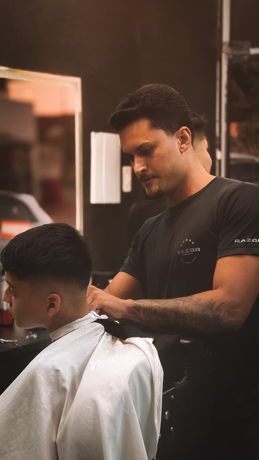 Barbeiro da Razor Barbearia finalizando um corte