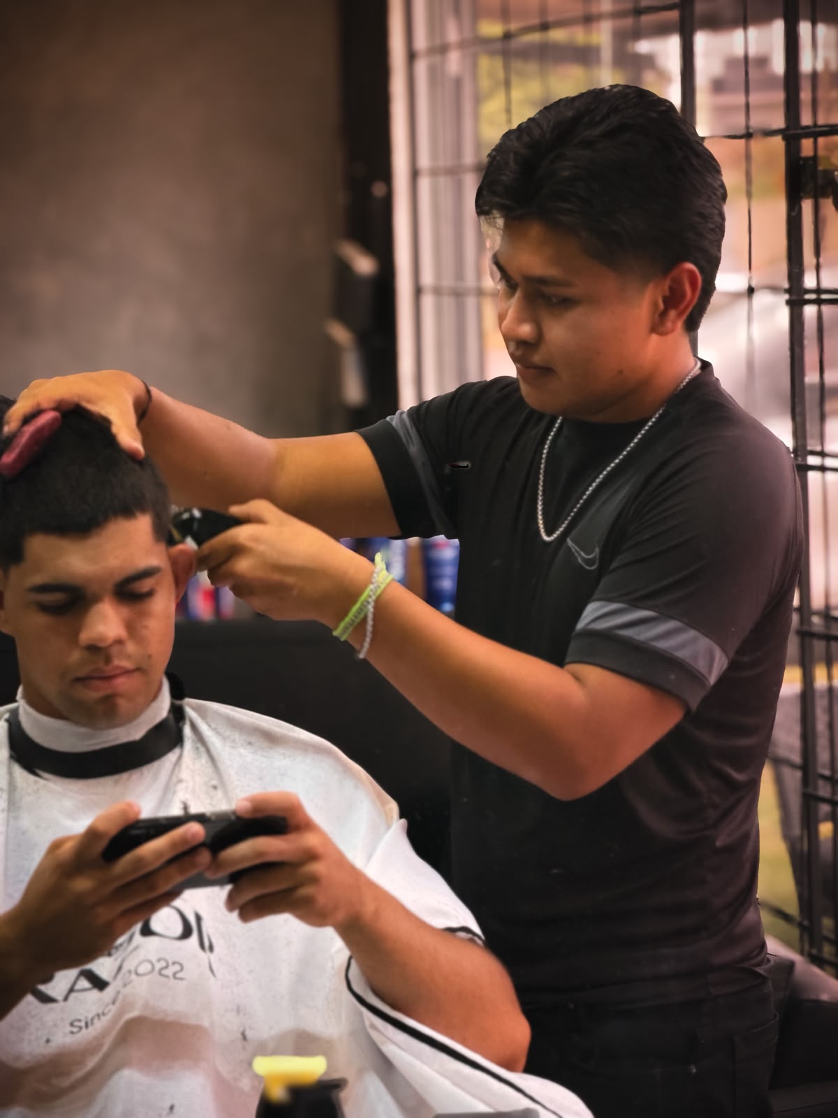Barbeiro executando um corte na máquina